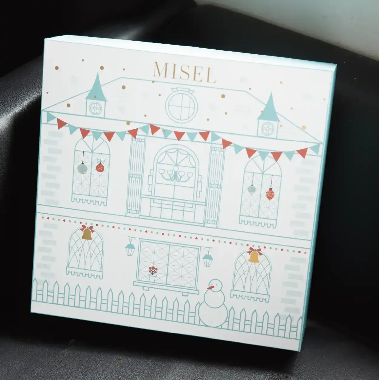 合上嘅 MISEL 倒數日曆封面: 薄荷綠線條白色屋、彩旗同燙金 Logo